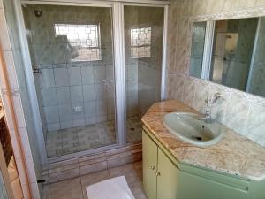 een badkamer met een wastafel en een douche bij Kgatholoha guest house in Klerksdorp