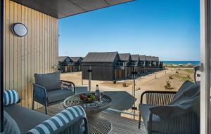 a balcony with a table and chairs and a view of the ocean at Havnehusene, Lejl, 58 in Slagelse