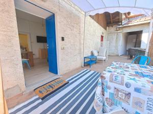 a room with a table and a blue door at Immobillario - Maison Felix in Gravedona