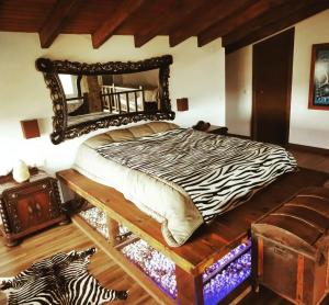 a bedroom with a zebra print bed with a mirror at Villamasai "Un pedacito de África en Valencia" in Valencia