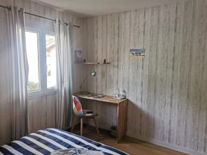 sypialnia z biurkiem, łóżkiem i oknem w obiekcie DUNE & OCEAN w mieście Le Haillan