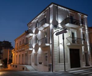 un bâtiment blanc avec un panneau de rue devant lui dans l'établissement Antico Palazzo del Corso, à Crosia