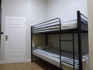 two bunk beds in a room with a door at Gingerbread Hostel in Toruń