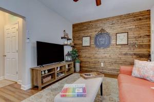 a living room with a couch and a flat screen tv at Mountain Bungalow-Walk to Downtown/Biker's Dream! in Hot Springs