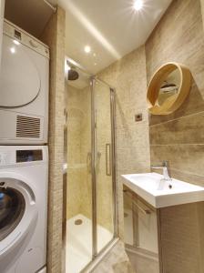 een badkamer met een wasmachine en een wastafel bij Beau 4 pièces avec grand jardin et tennis in Jouy-en-Josas