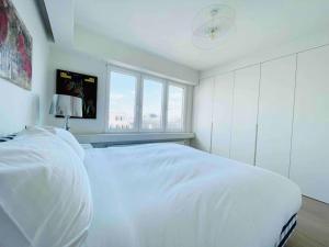 a white bedroom with a white bed and a window at Luxurious 1 bedroom in the Heart of City Center - 25 in Luxembourg