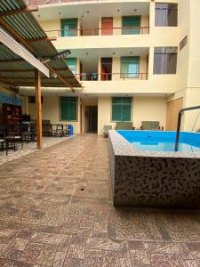 a building with a pool in the middle of a courtyard at Hostel Boulevard in Ica