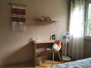 biurko w sypialni z krzesłem i wentylatorem w obiekcie DUNE & OCEAN w mieście Le Haillan