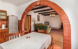 eine Küche mit einem Tisch und einem Backsteinbogen in der Unterkunft Lovely Apartment In Lopar With House A Panoramic View in Lopar