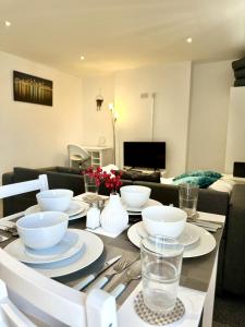 a table with bowls and plates on it in a living room at Courtyard Stay in Norwich