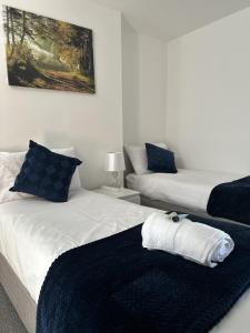 a bedroom with two beds with a towel on it at Courtyard Stay in Norwich