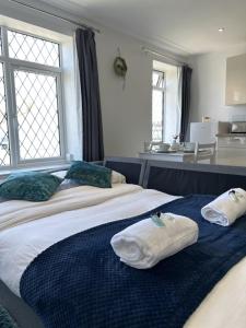 two beds in a room with towels on them at Courtyard Stay in Norwich