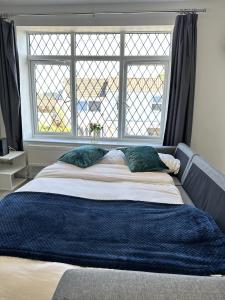 a large bed with two pillows in front of a window at Courtyard Stay in Norwich