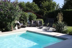 a swimming pool with lounge chairs next to a yard at Au Temps de Spa - La Tour du Tonnelet in Spa