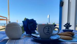 Una mesa con dos tazas de café y galletas. en Blue Velvet, en Punta Secca