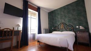 1 dormitorio con cama y pared verde en Hostal La Trucha Sanabria, en Puebla de Sanabria
