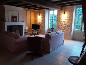 sala de estar con muebles blancos y chimenea en La Galerne, en Montpellier-de-Médillan