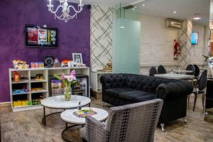 a salon with a couch and tables and chairs at Ker Belgrano Hotel in Buenos Aires