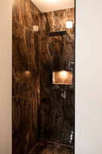 a bathroom with a shower with a black stone wall at Botanique Suites AirBnB, Antwerp in Antwerp