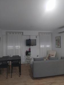 uma sala de estar com um sofá e uma mesa em SANTO ANGEL 7 em Sevilha