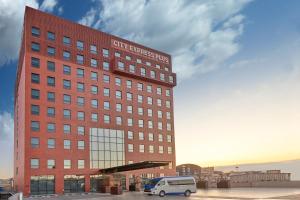 um edifício com uma carrinha estacionada em frente em City Express Plus by Marriott Tijuana em Tijuana