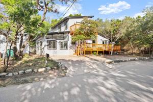 una gran casa blanca con terraza en una calle en Lux Lake Travis en Austin