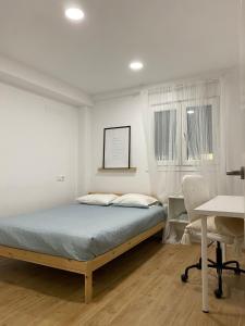 um quarto com uma cama, uma mesa e uma secretária em SANTO ANGEL 7 em Sevilha