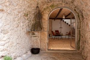 an archway in a stone wall with a mirror at Sisters-Homes Vidovići 9 in Martinšćica