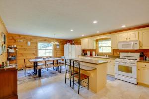 una cocina con electrodomésticos blancos y una mesa con sillas. en Serene Mountain Retreat on 40 Acres with Fire Pit!, 