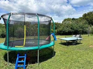 a trampoline and a table in the grass at Efis & Michaelas House! in Danilia