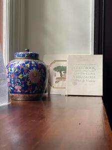洛桑的住宿－Le Chalet d'Ouchy，坐在书旁边的桌子上的花瓶