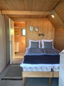 a bedroom with a bed in a wooden cabin at Nexø Camping & Cabins in Neksø