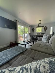 uma sala de estar com um sofá e uma mesa em Modern, Sunset Waterfront Cottage with EV Charger em Yarker