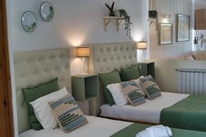 um quarto com 2 camas e almofadas em Duna Parque Beach Club - Duna Parque Group em Vila Nova de Milfontes