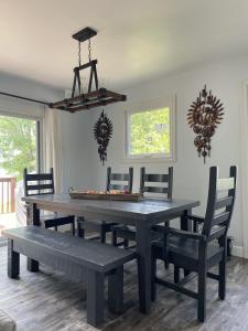 a dining room table with chairs and a bench at Modern, Sunset Waterfront Cottage with EV Charger in Yarker