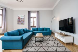 a living room with a blue couch and a tv at Beautiful apartment, great location, Old Town & Kazimierz in Kraków