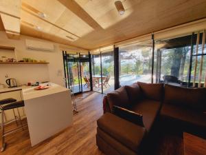 eine Küche und ein Wohnzimmer mit einem Sofa und einem Tisch in der Unterkunft Colores de Manantiales in Villa General Belgrano