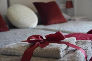 a towel with a red ribbon on a bed at Sueña Toledo in Toledo