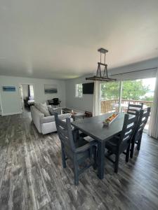 a living room with a table and chairs and a couch at Modern, Sunset Waterfront Cottage with EV Charger in Yarker