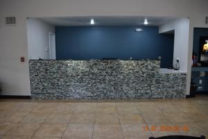 a stone wall in a room with a blue wall at Executive Inn NEWLEY RENOVATED in Baker