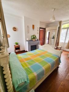 a bedroom with a bed with a colorful blanket at Auberge du Crabère in Melles