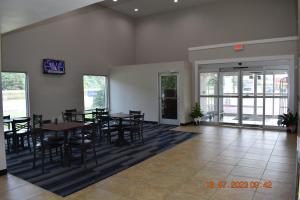 Executive Inn NEWLEY RENOVATED في Baker: غرفة طعام مع طاولات وكراسي في مبنى