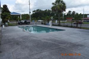 una piscina en un aparcamiento con una valla en Executive Inn NEWLEY RENOVATED, en Baker
