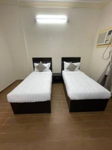 two beds sitting next to each other in a room at شهد الثانية للشقق المخدومة in Al ‘Abābīd