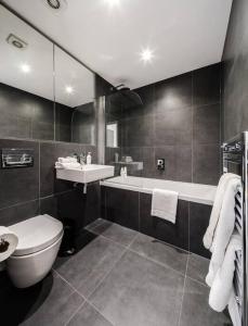 a bathroom with a toilet and a sink and a tub at Stunning 2 Bed 2 Bath Apartment in Clerkenwell in London