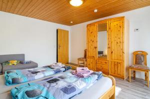 a bedroom with two beds and a wooden ceiling at Carmen in Wald