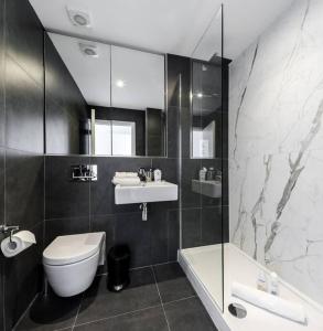a bathroom with a toilet and a sink and a shower at Stunning 2 Bed 2 Bath Apartment in Clerkenwell in London