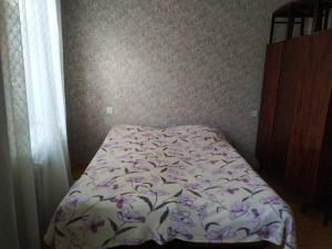 - une chambre dotée d'un lit avec un couvre-lit floral dans l'établissement Friends Guest House, à Gandja