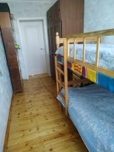 1 dormitorio con 2 literas y suelo de madera en Friends Guest House, en Ganja