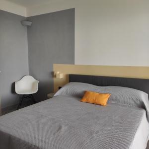 a bedroom with a bed with an orange pillow on it at Locanda Göghin in Pieve Ligure